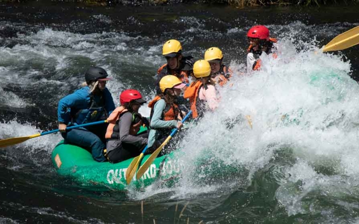 a group of gap year students paddle a raft through whitewater on an outward bound semester expedition 